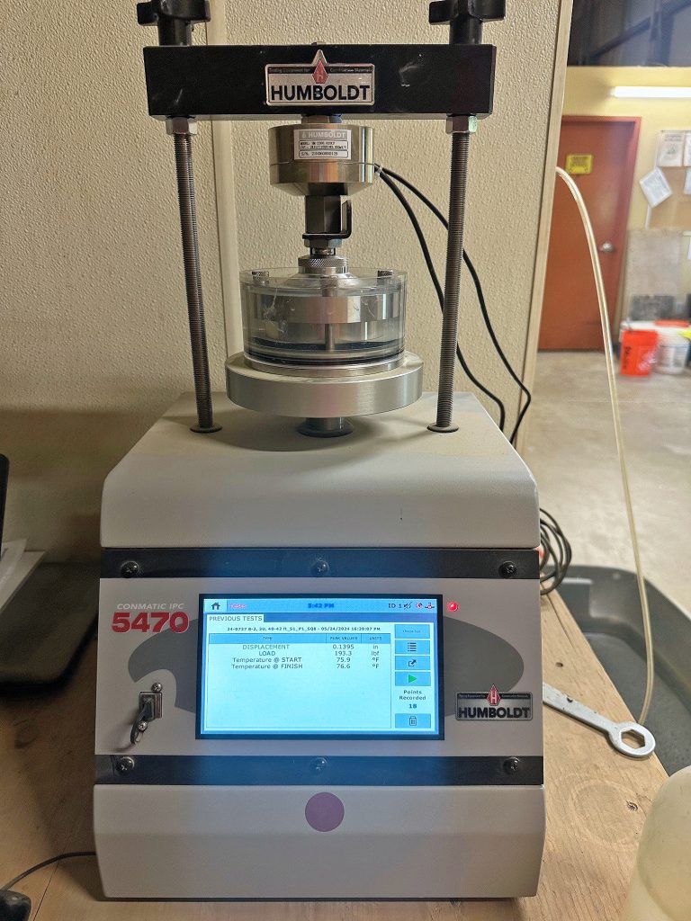 Machine performing a soil consolidation test