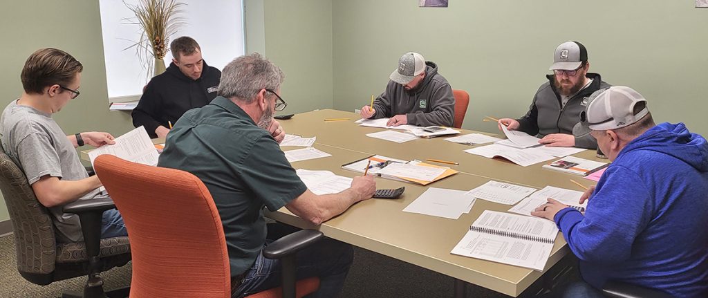 Employees working around a large table.