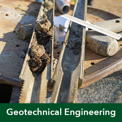 Open split spoon sampler with soil samples and other geotechnical engineering tools.