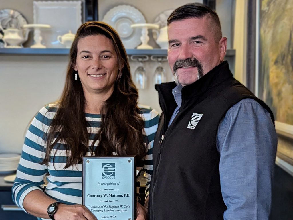 Courtney Mattson with a plaque commemorating her graduation from the Emerging Leaders program accompanied by CEO Bob Chaput.