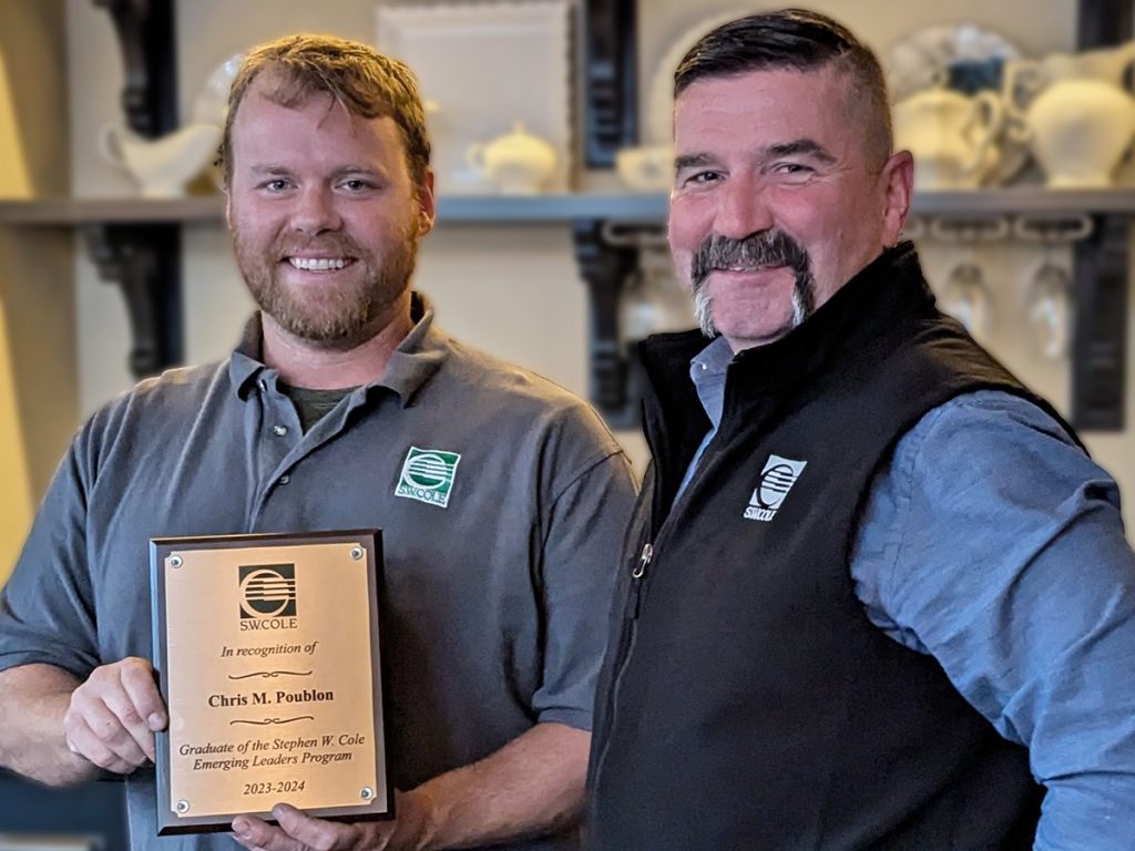 Chris Poublon with a plaque commemorating his graduation from the Emerging Leaders program accompanied by CEO Bob Chaput.