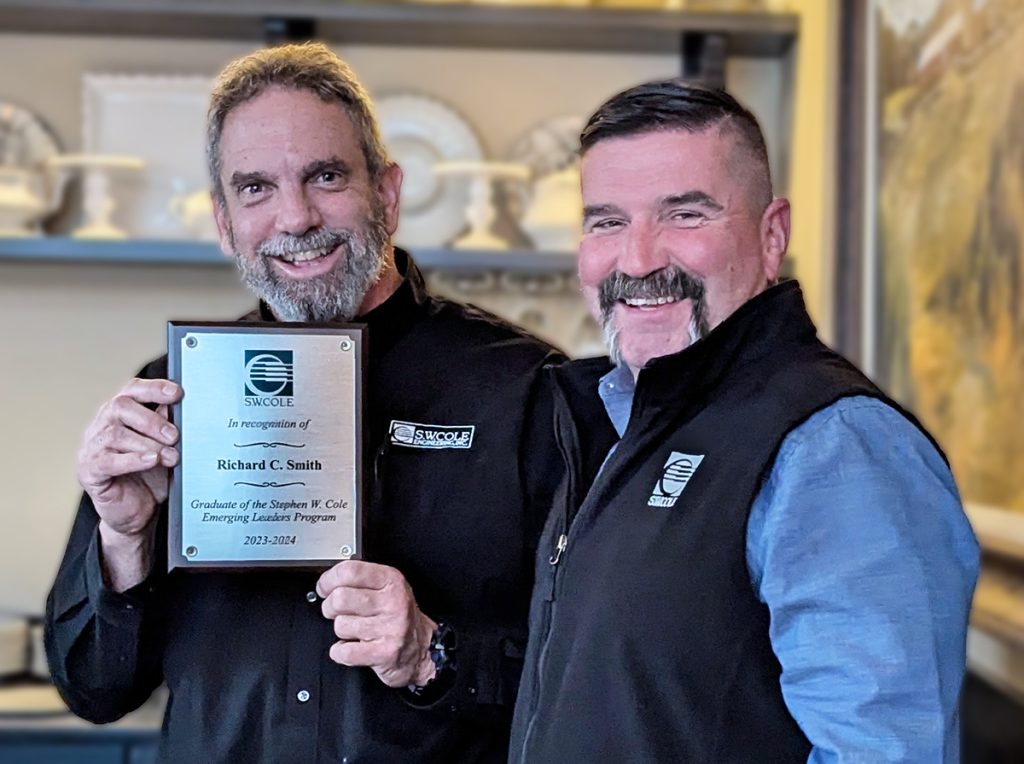 Richard Smith with a plaque commemorating his graduation from the Emerging Leaders program accompanied by CEO Bob Chaput.