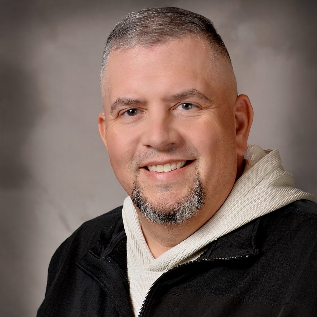 Professional headshot photo of Derek Mello
