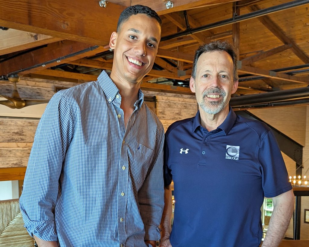 Edwardo Baldera Mendez with his Emerging Leaders mentor, Dave Dunning, standing next to each other and smiling in an indoor space.